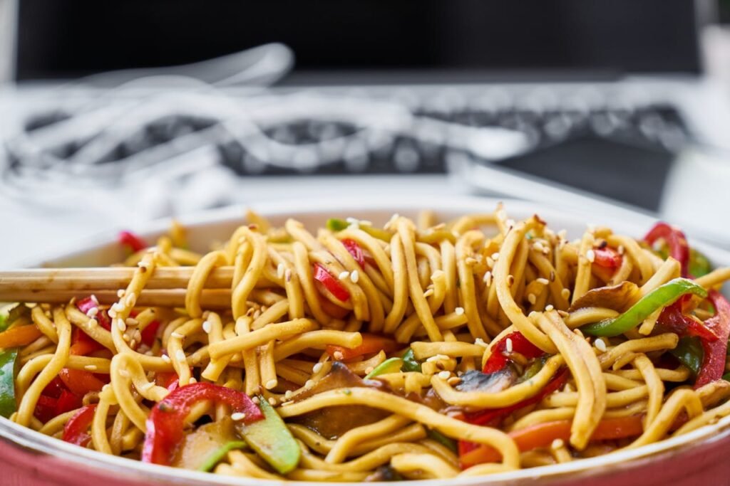 Colorful stir-fried noodles with vegetables and sesame seeds, perfect for an appetizing meal.